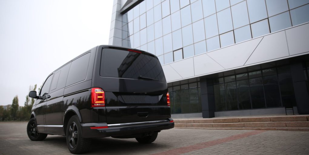 Black delivery van parked on street near building